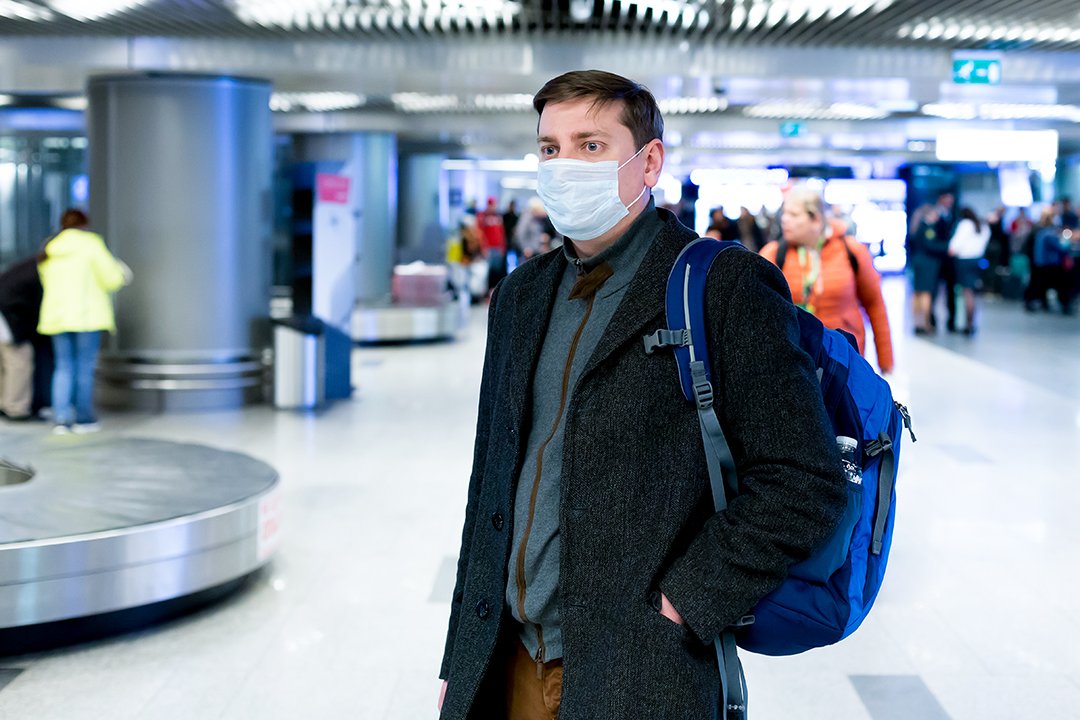 Mann mit Maske am Flughafen