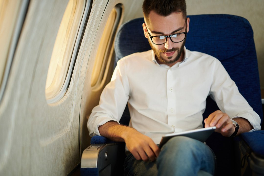 Mann liest im Privatflugzeug