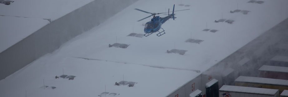 Hubschrauber über schneebedecktem Dach